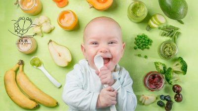 A baby sitting in a high chair, refusing food while a parent offers a spoonful.