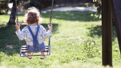 A baby peacefully sleeping in a swing, highlighting concerns about safety for infant sleeping in swings.