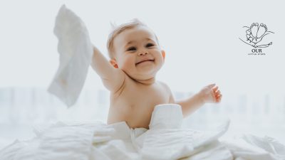 A stack of colorful diapers alongside a baby, representing diaper options and care.
