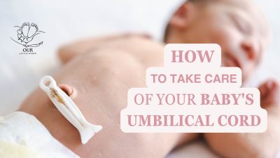 Close-up of a newborn's belly button with a healing umbilical cord stump, gently cleaned by a parent.