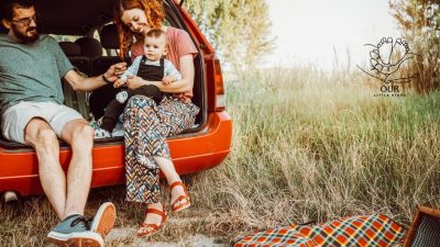 Parent holding a baby at the airport with travel bags, ready for an adventure